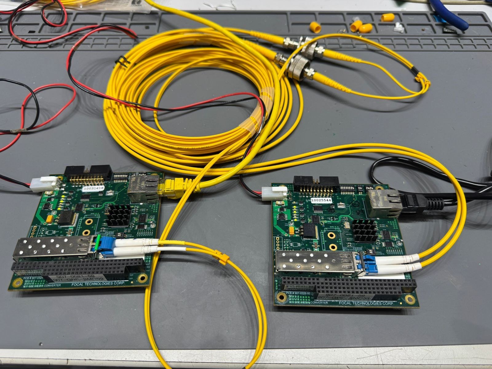 Duas placas media converter Focal Technologies Corp. em bancada, conectadas por fibra óptica